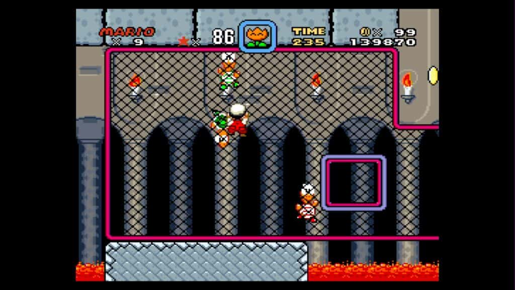 Mario confronts some Koopas while clinging to the side of a metal grate.