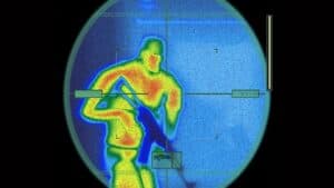 A screenshot from Tom Clancy's Splinter Cell, featuring an enemy seen through a scope with thermal imaging active